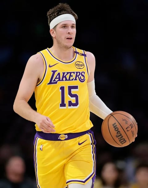 NBA player wearing Lakers number 15 yellow jersey holding basketball during game
